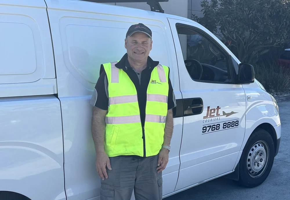 Jet Couriers Owner Driver standing beside his white delivery van
