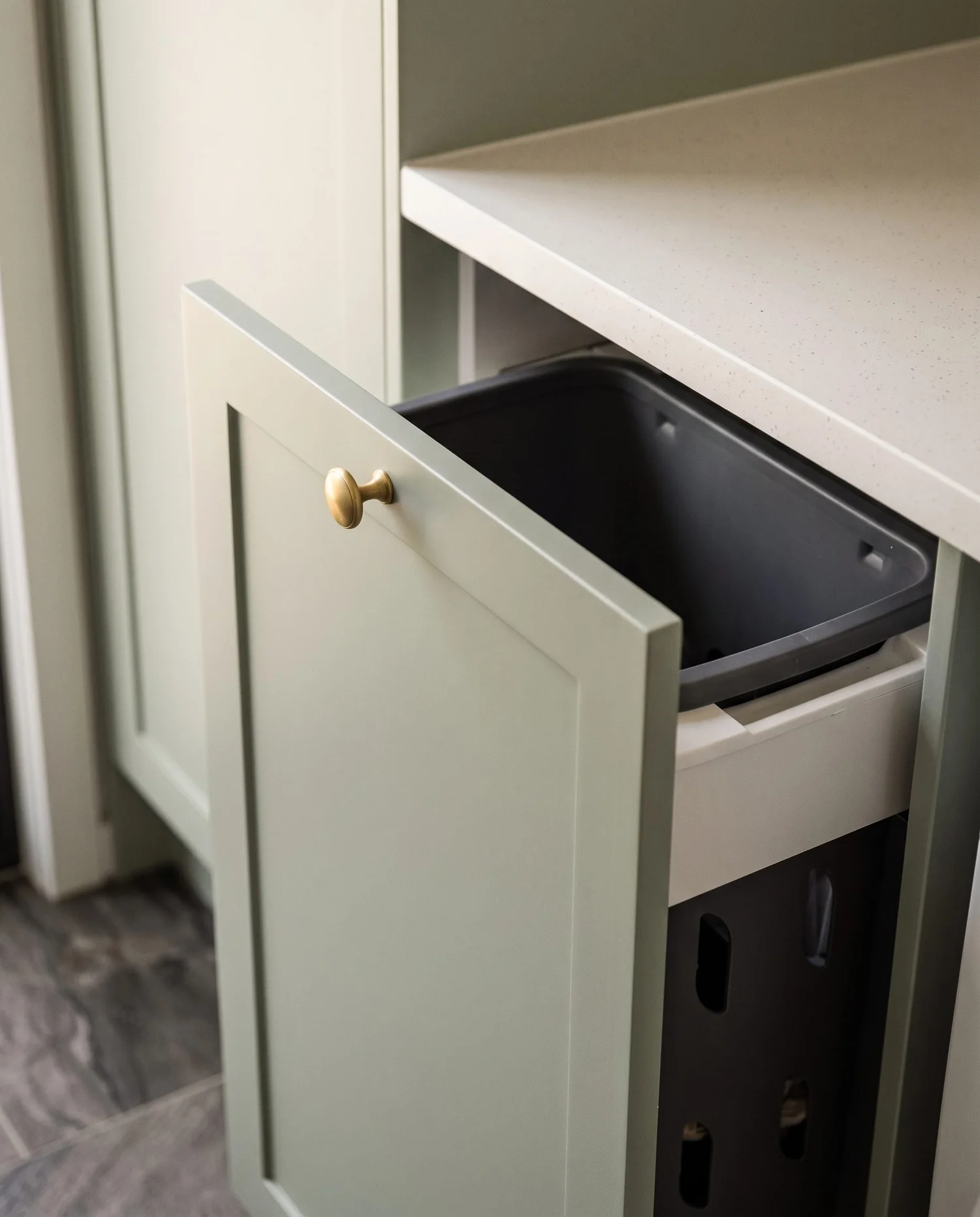 Integrated pull-out bin and hamper storage inside the laundry joinery