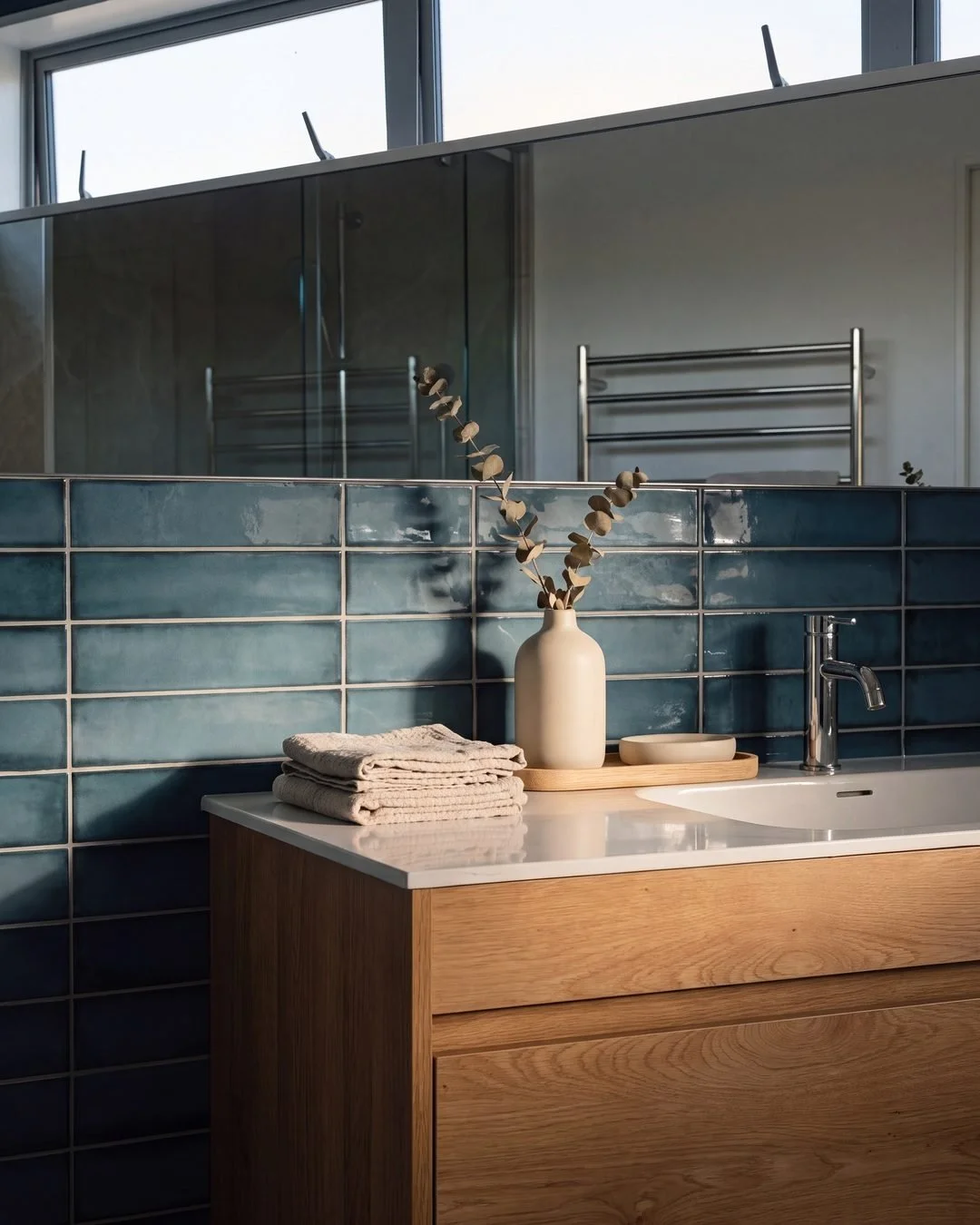 Oak vanity, stone benchtop and deep blue gloss tile wall in the Sandringham master ensuite