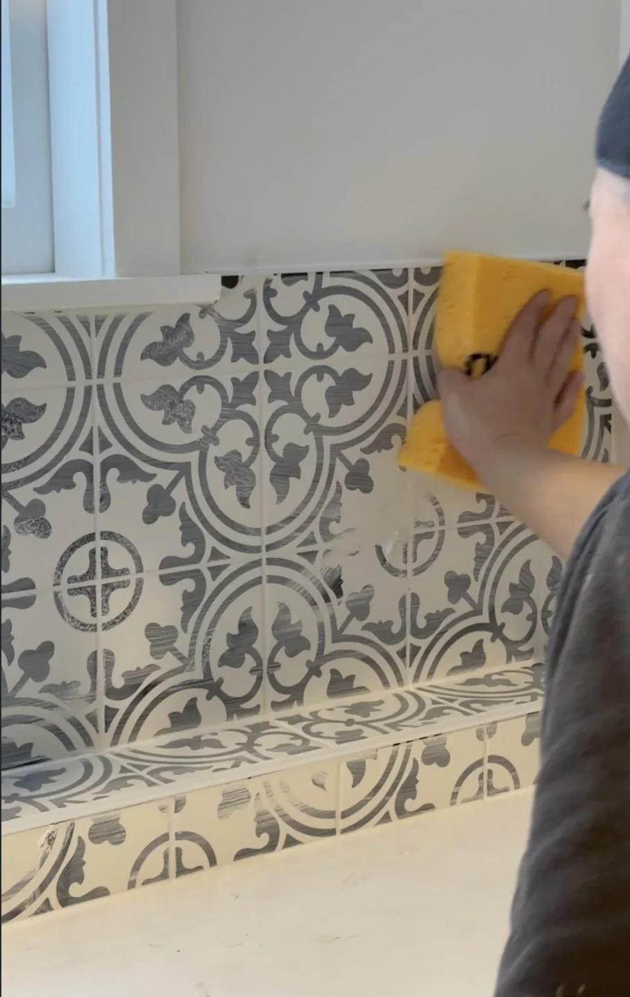 Grout being sponged off the encaustic tile in the Merani Street laundry bathroom, Belmont
