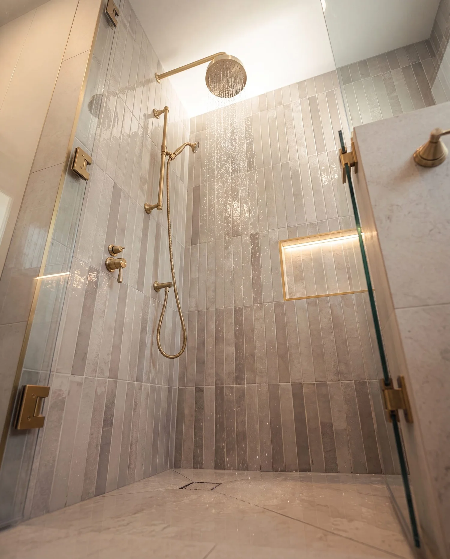 Walk-in shower with brushed brass rainfall head, handheld on rail and LED-lit niche, Garfield Street Parnell