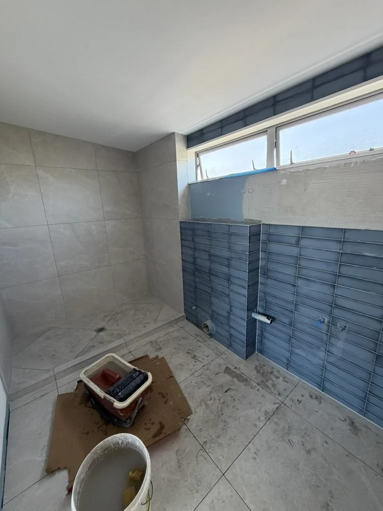 Part-tiled blue gloss feature wall in the Sandringham ensuite renovation
