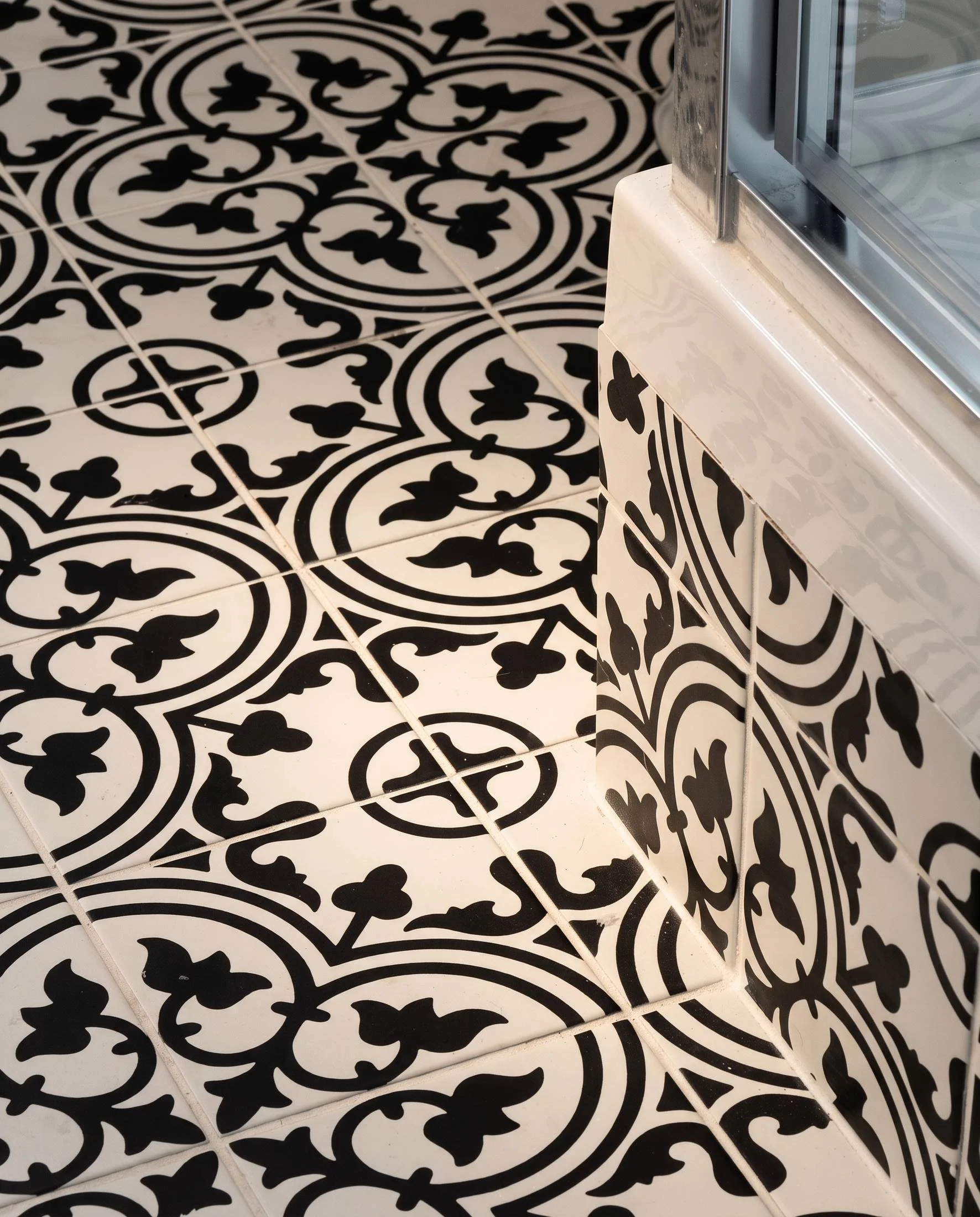 Laundry and bathroom renovation in Belmont, Auckland: Merani Street with stacked washer and dryer, stainless sink and black and white encaustic tile