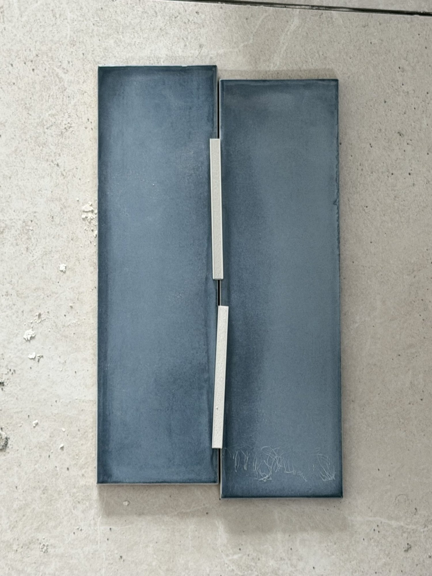 Deep blue gloss tile samples laid out on the floor during the Patterson Street ensuite renovation