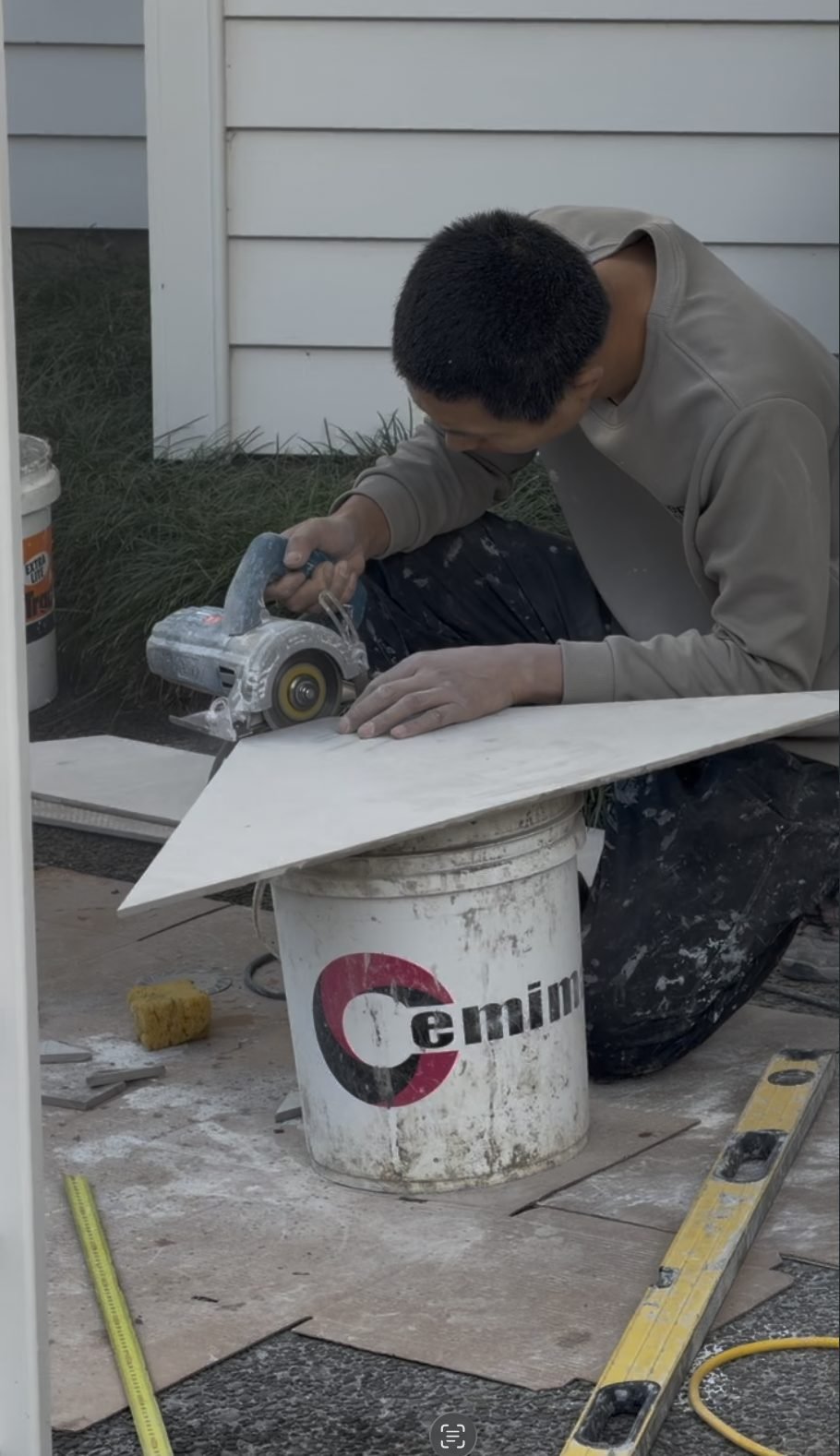 Large-format porcelain slab being cut on site by hand during the Greenhithe master bathroom renovation