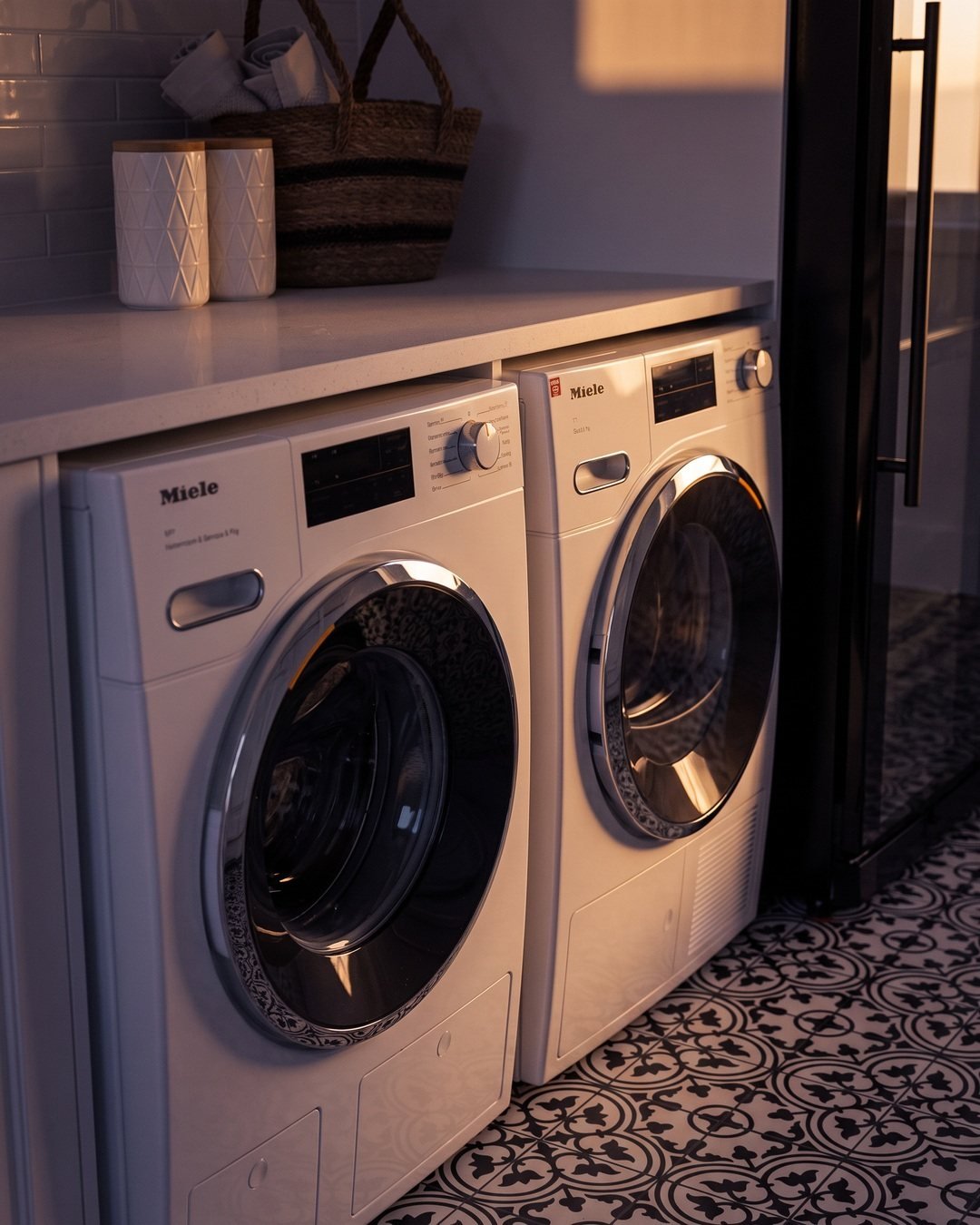 Washer and dryer under the stone benchtop in warm light, Seymour Street laundry renovation