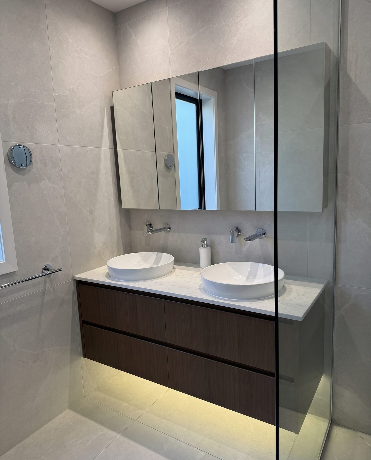 Walnut floating double vanity with stone benchtop and twin vessel basins in the Greenhithe master bathroom
