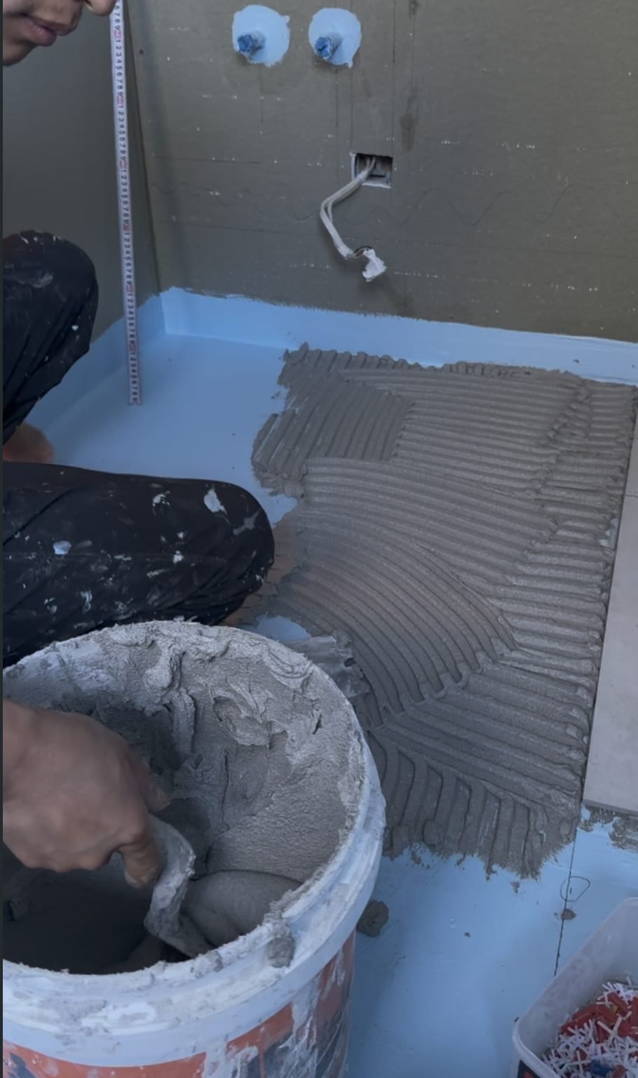 Tile adhesive being combed onto the shower wall during the Parnell bathroom renovation