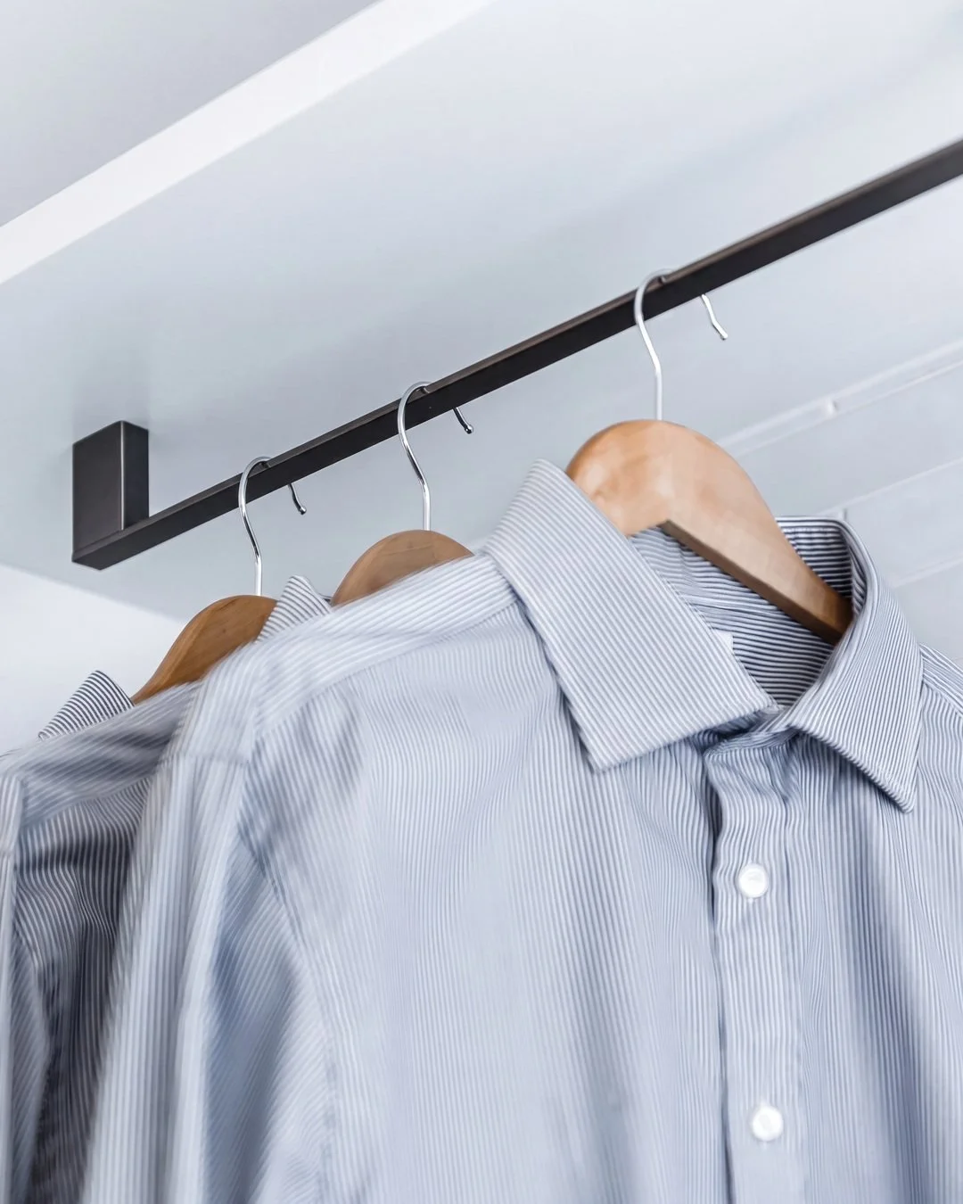 Blackened steel hanging rail with timber hangers in the St Marys Bay galley laundry