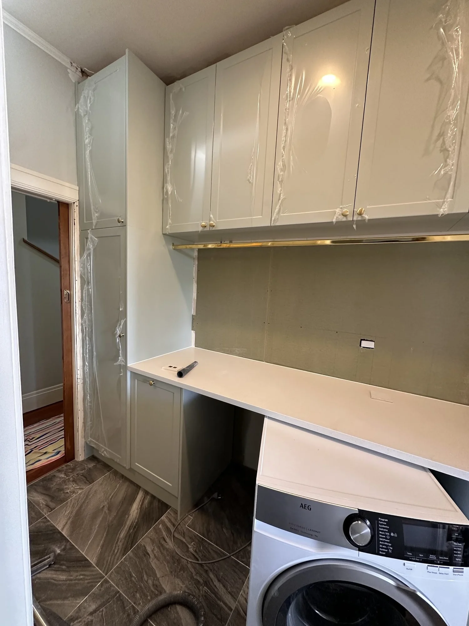 Dezignatek Series 3 shaker cabinetry in Pistachio being installed in the Bayswater laundry