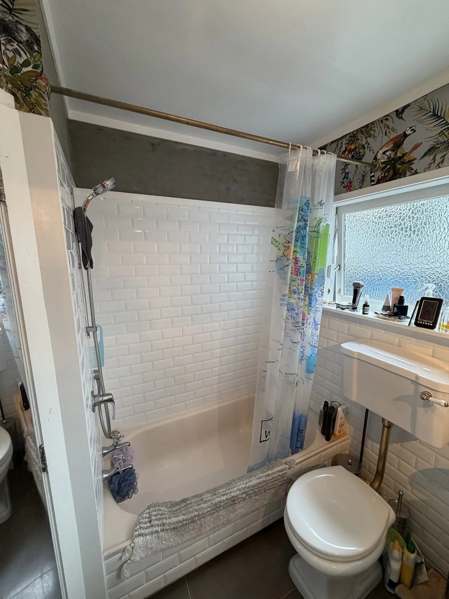 Parnell bathroom before renovation on Garfield Street with white subway tiles, tropical wallpaper border and a shower over the bath