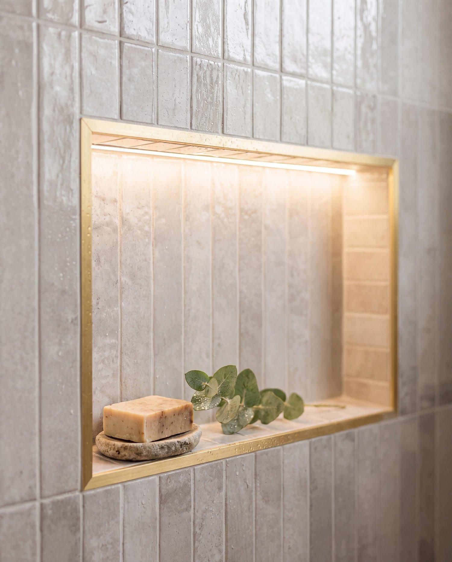 LED-lit brass-framed shower niche in grey vertical stack-bond tile, Parnell bathroom renovation