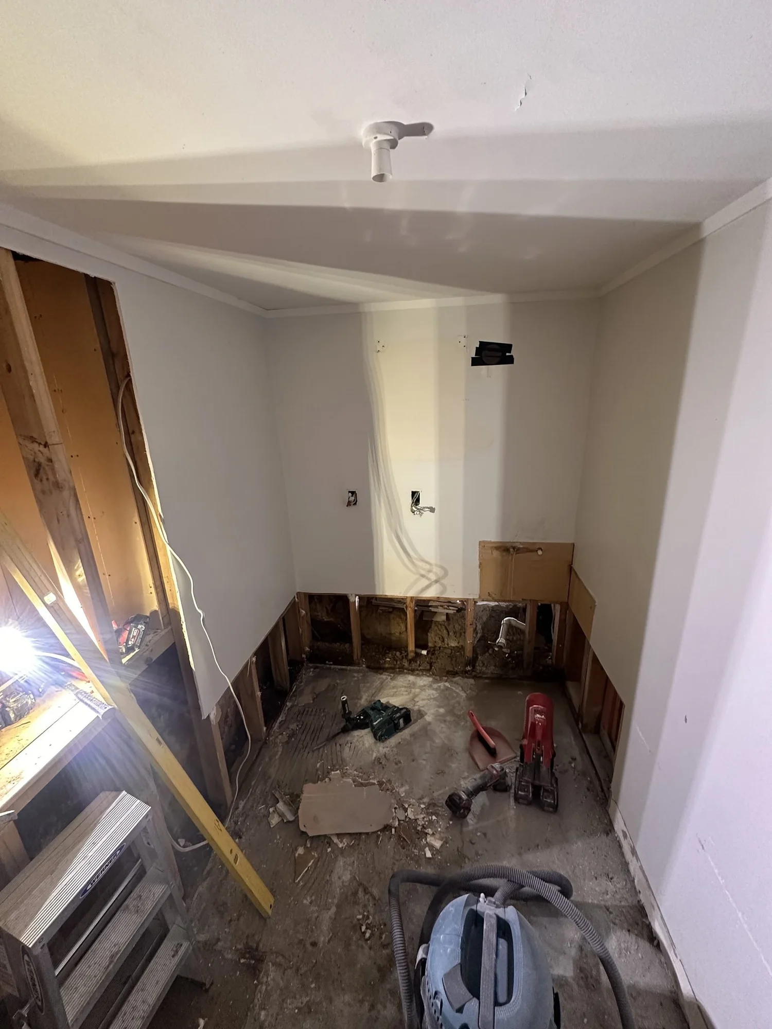 St Heliers laundry stripped to bare concrete floor and exposed studs during demolition