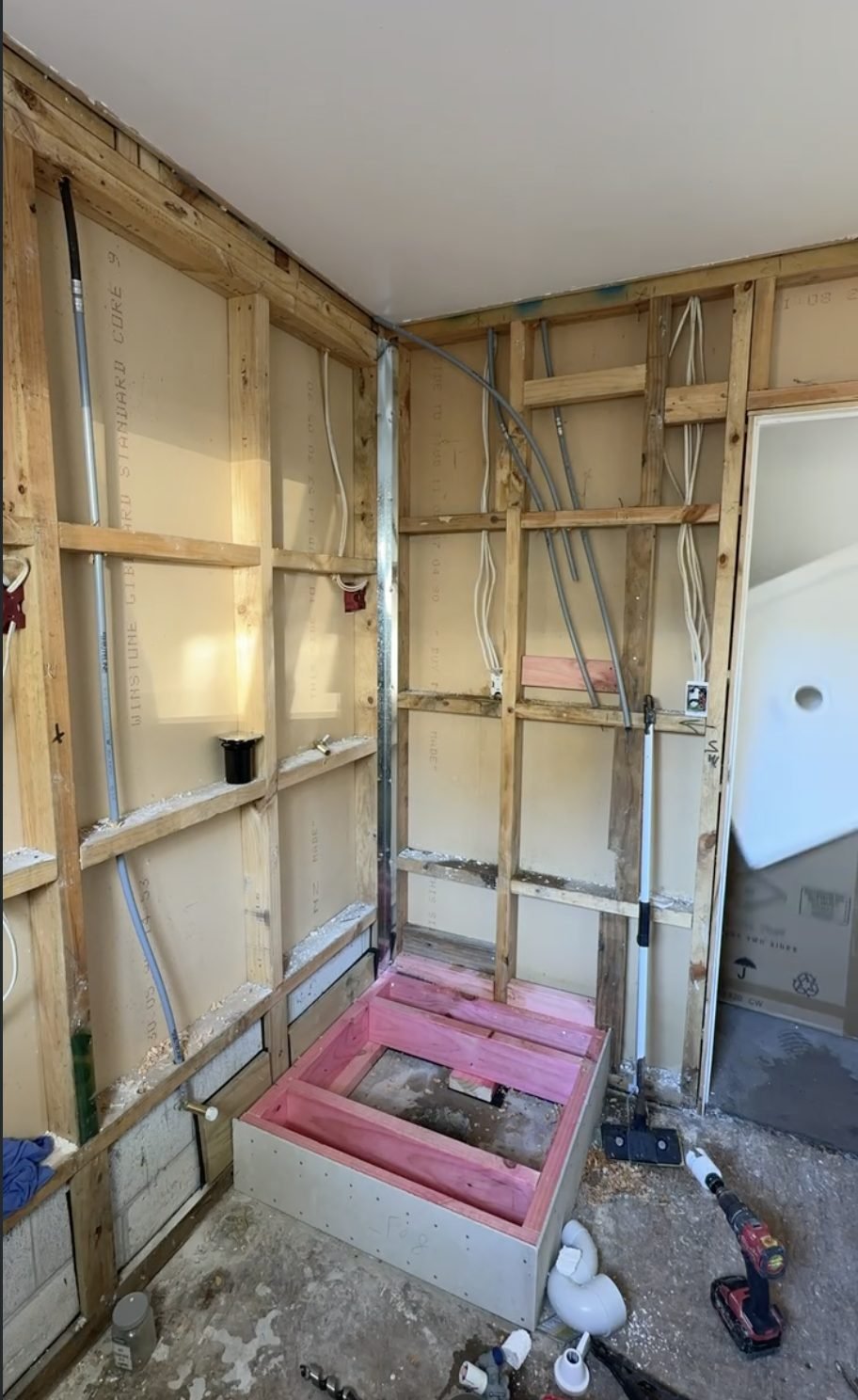 Belmont laundry bathroom stripped back to bare timber framing and concrete during renovation