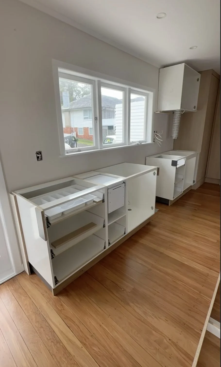 White cabinetry carcasses being installed in the Merani Street kitchen, Belmont