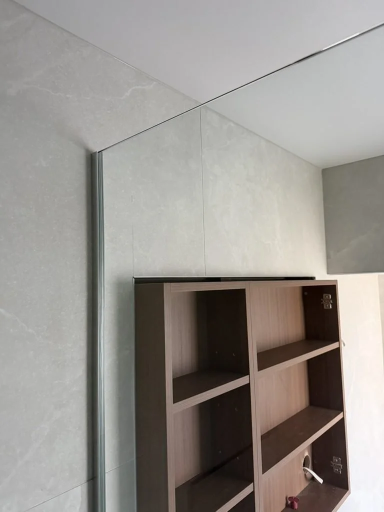 Mirror cabinet being fixed to the finished large-format tile in the Greenhithe family bathroom