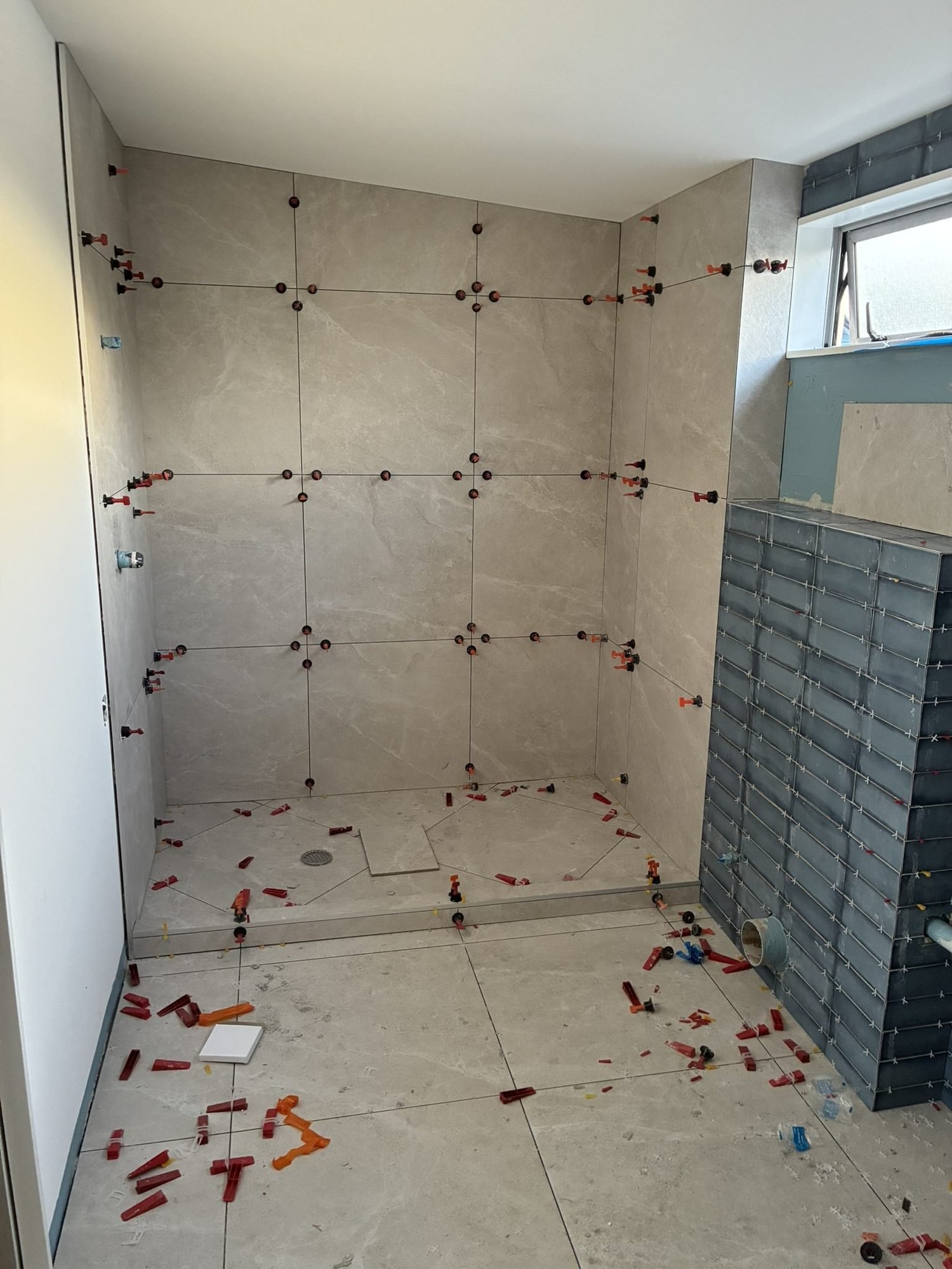 Tile setting out with spacers across the floor and walls of the Patterson Street ensuite