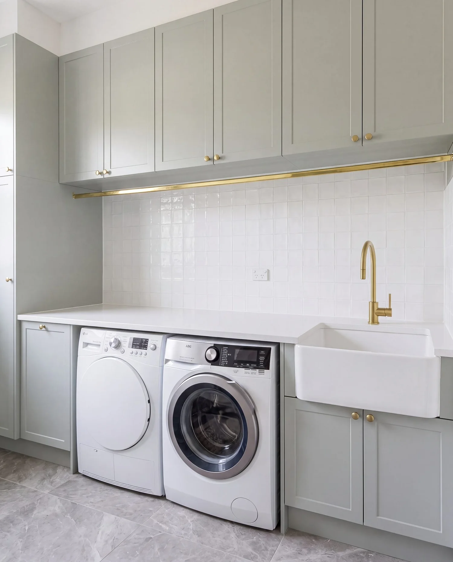 Floor to ceiling laundry storage cupboards in soft sage shaker joinery