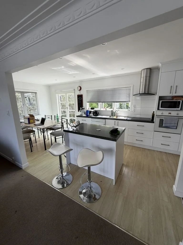 Merani Street kitchen in Belmont before renovation, white cabinetry with a dark benchtop and island