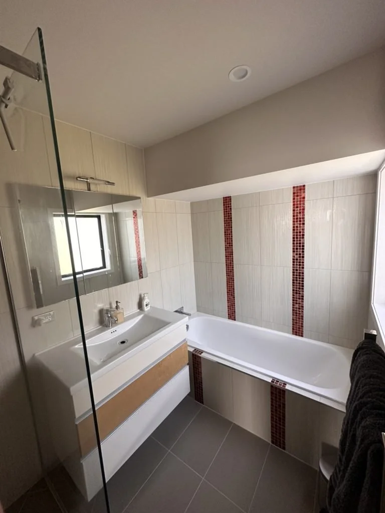 Churchouse Road family bathroom in Greenhithe before renovation, cream tile with a red mosaic feature stripe, trough basin and built-in bath