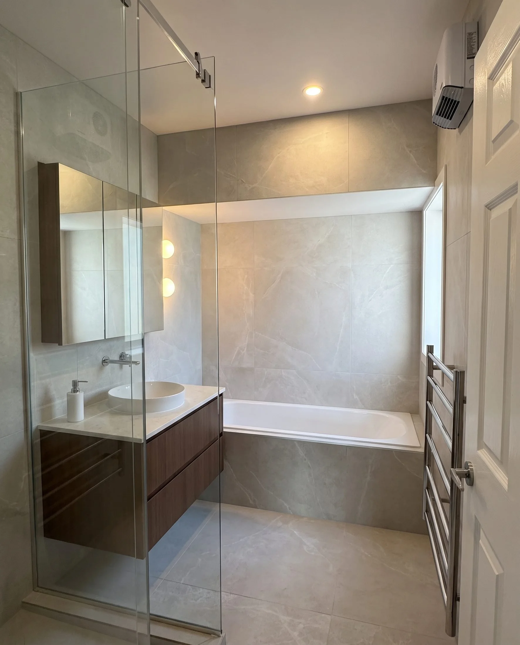 Family bathroom renovation in Greenhithe, Auckland: Churchouse Road bathroom with large-format porcelain, walnut vanity and a built-in bath