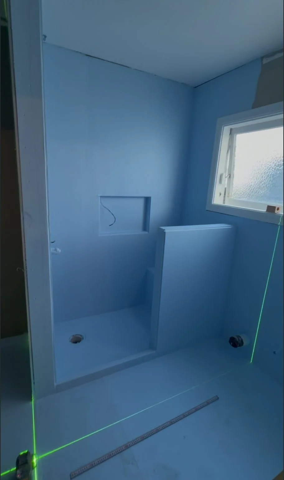 Waterproofing membrane over the shower niche and built-in bench seat with laser level, Garfield Street Parnell