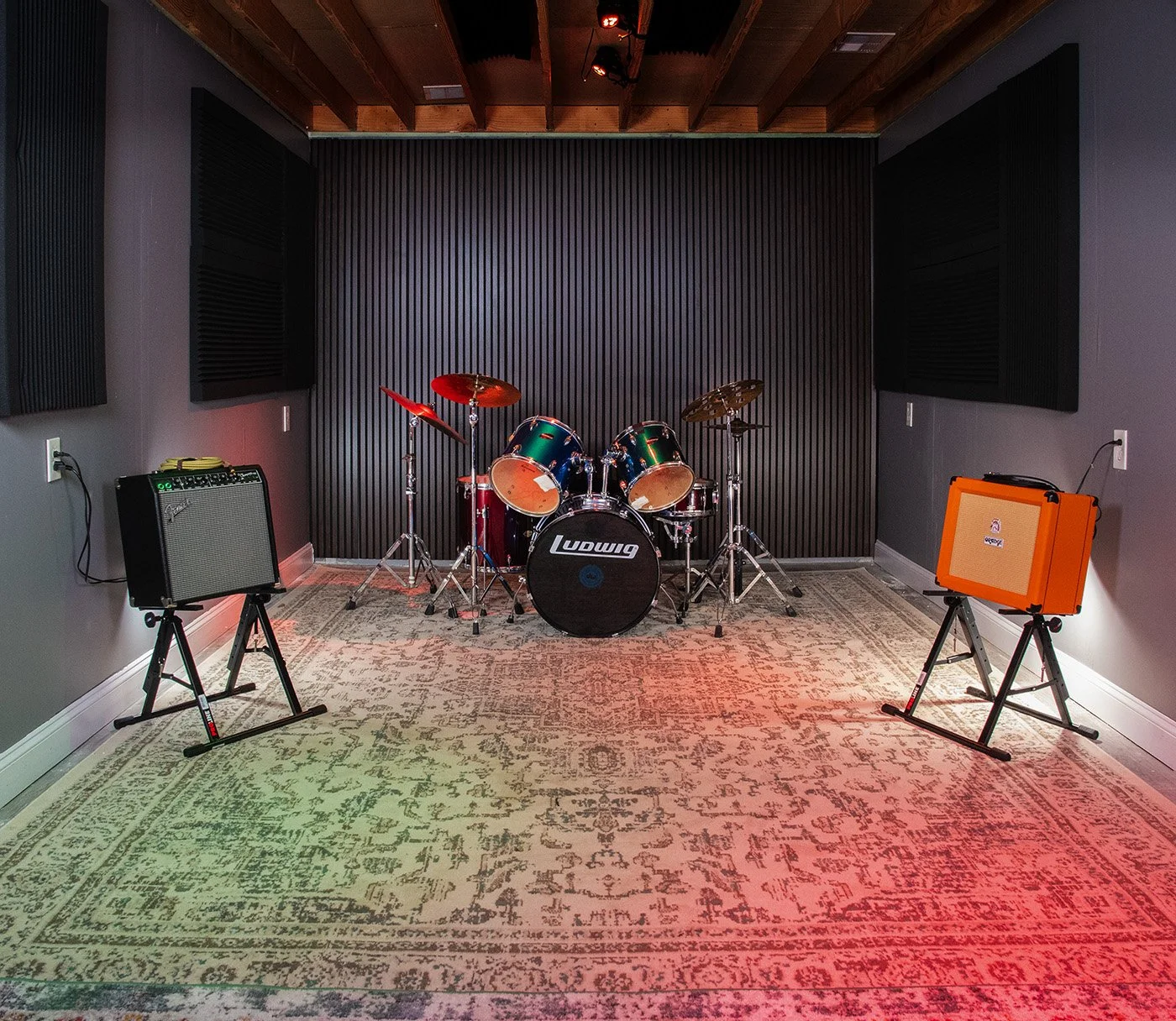 The Jam Space room with a Ludwig drum kit, guitar amplifiers, and acoustic wall panels