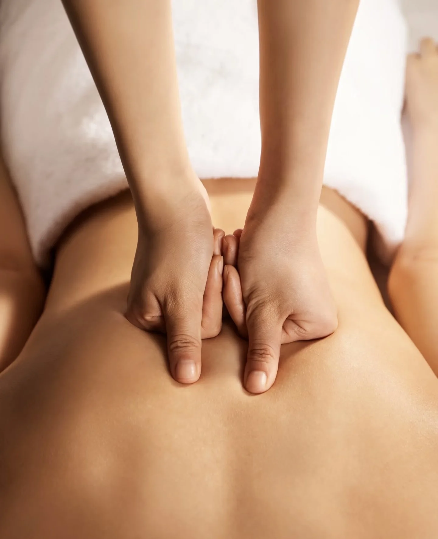 Therapist’s hands applying massage pressure to the back