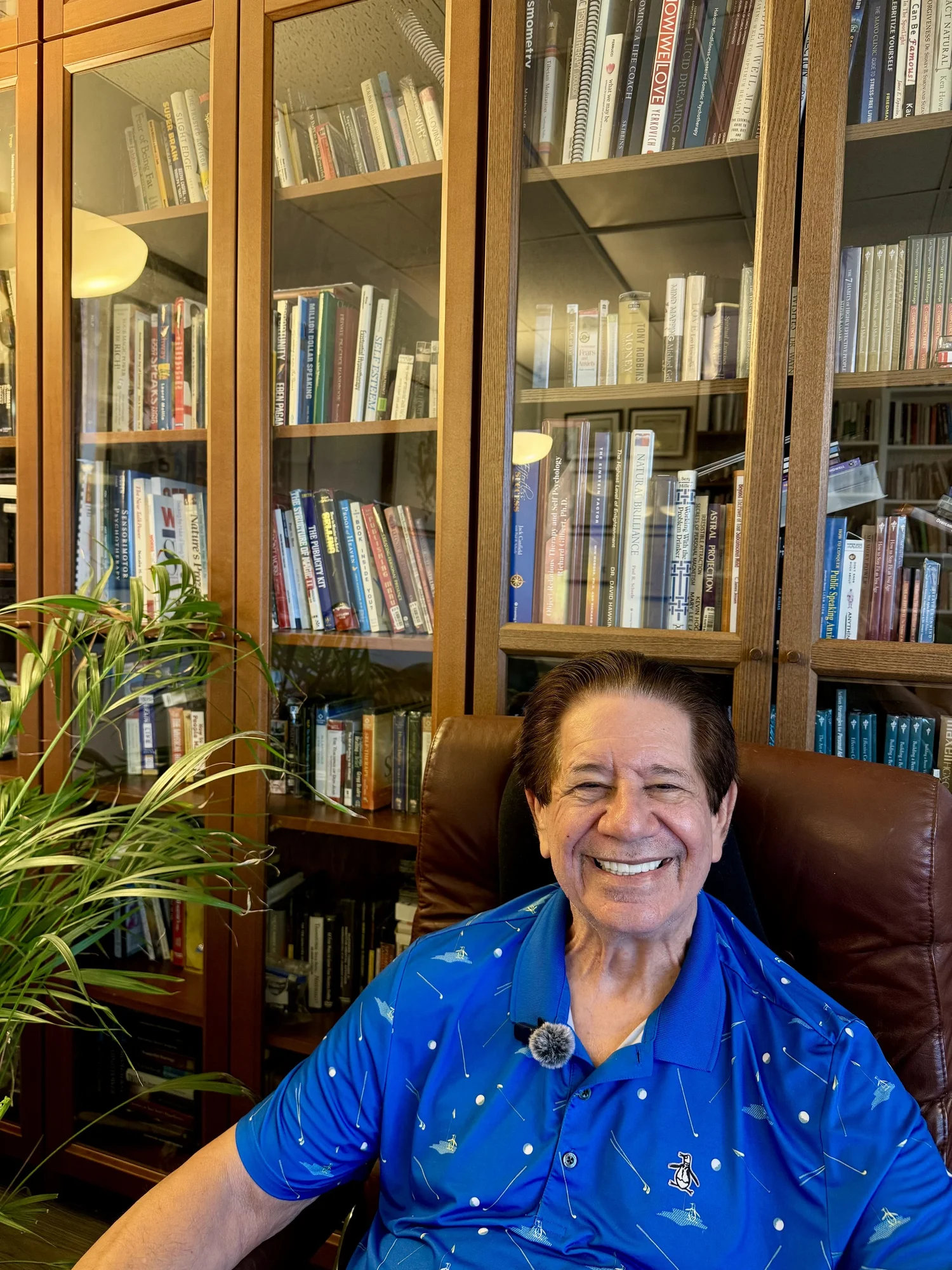 Dr. Robert Jaffe in his office library, seated in front of floor-to-ceiling bookshelves