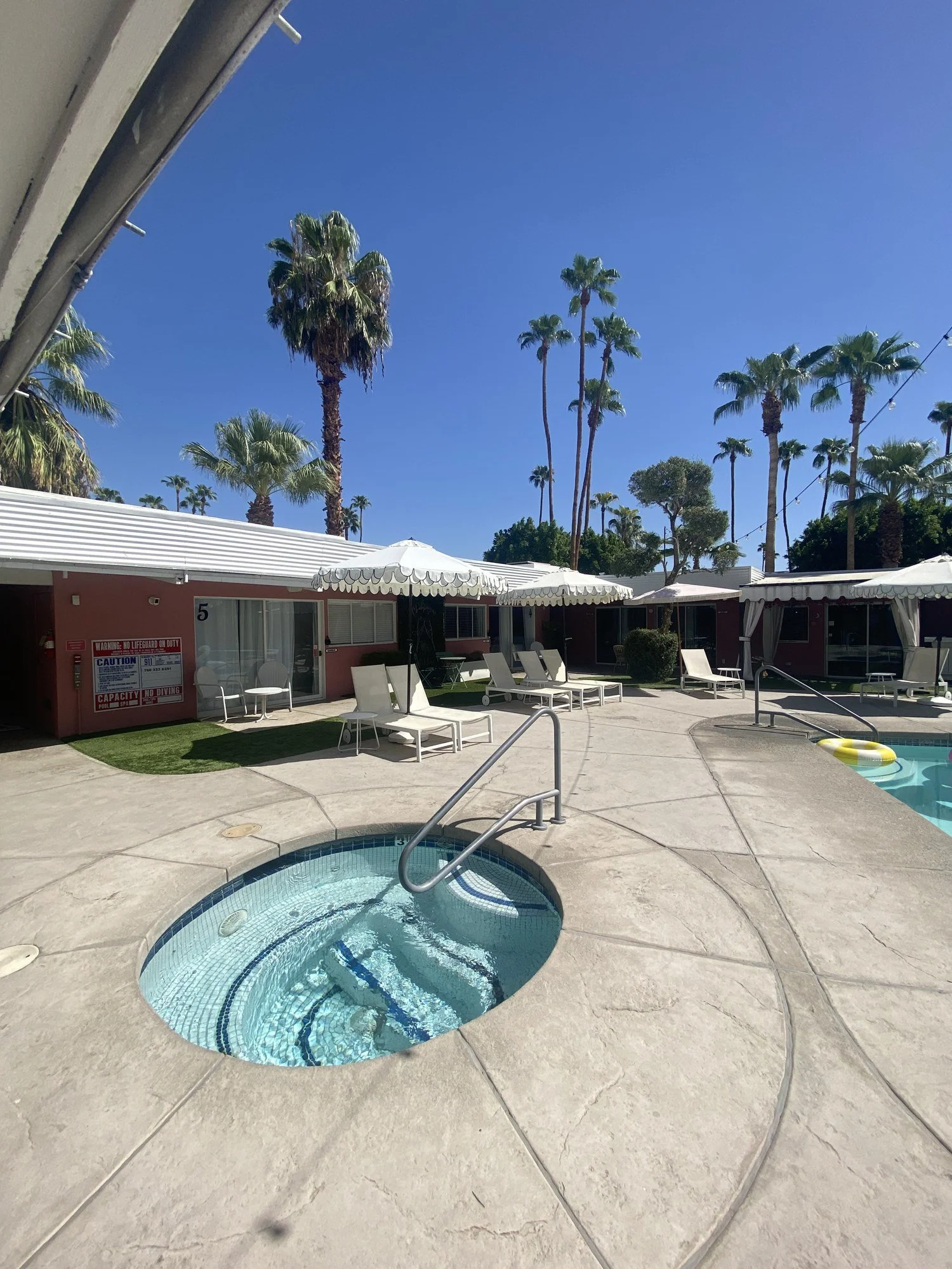 The hot tub and loungers under scalloped umbrellas