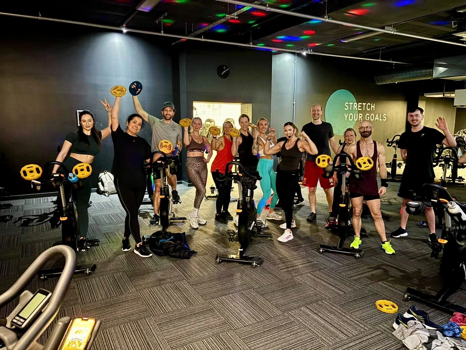 Weight to Spin class members holding small weight plates in the spin studio