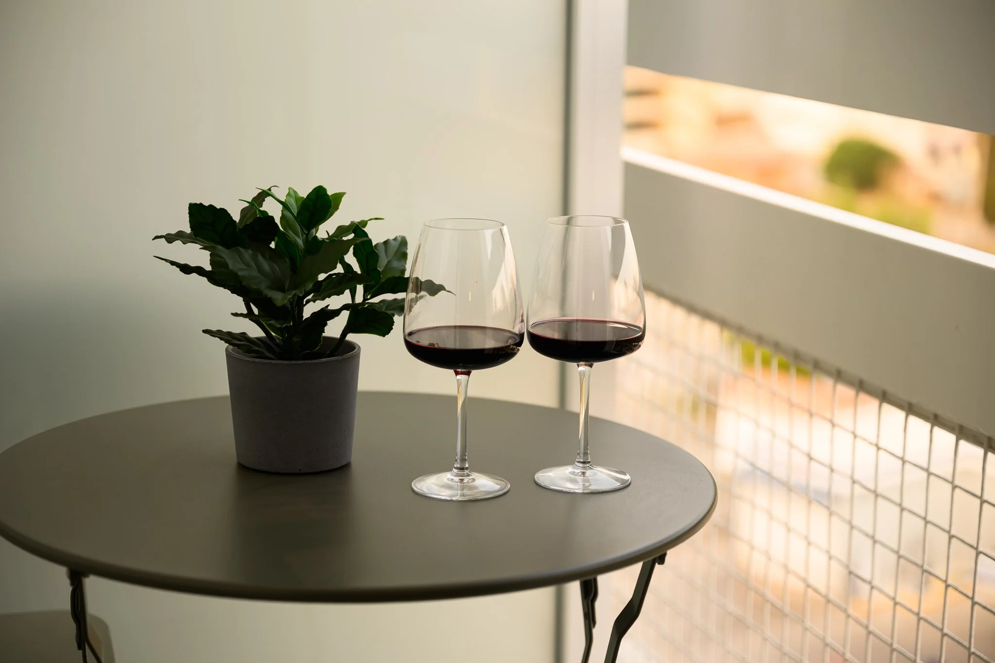 Two glasses of red wine on the Corner Suite balcony at Nisia Suites, Nicosia
