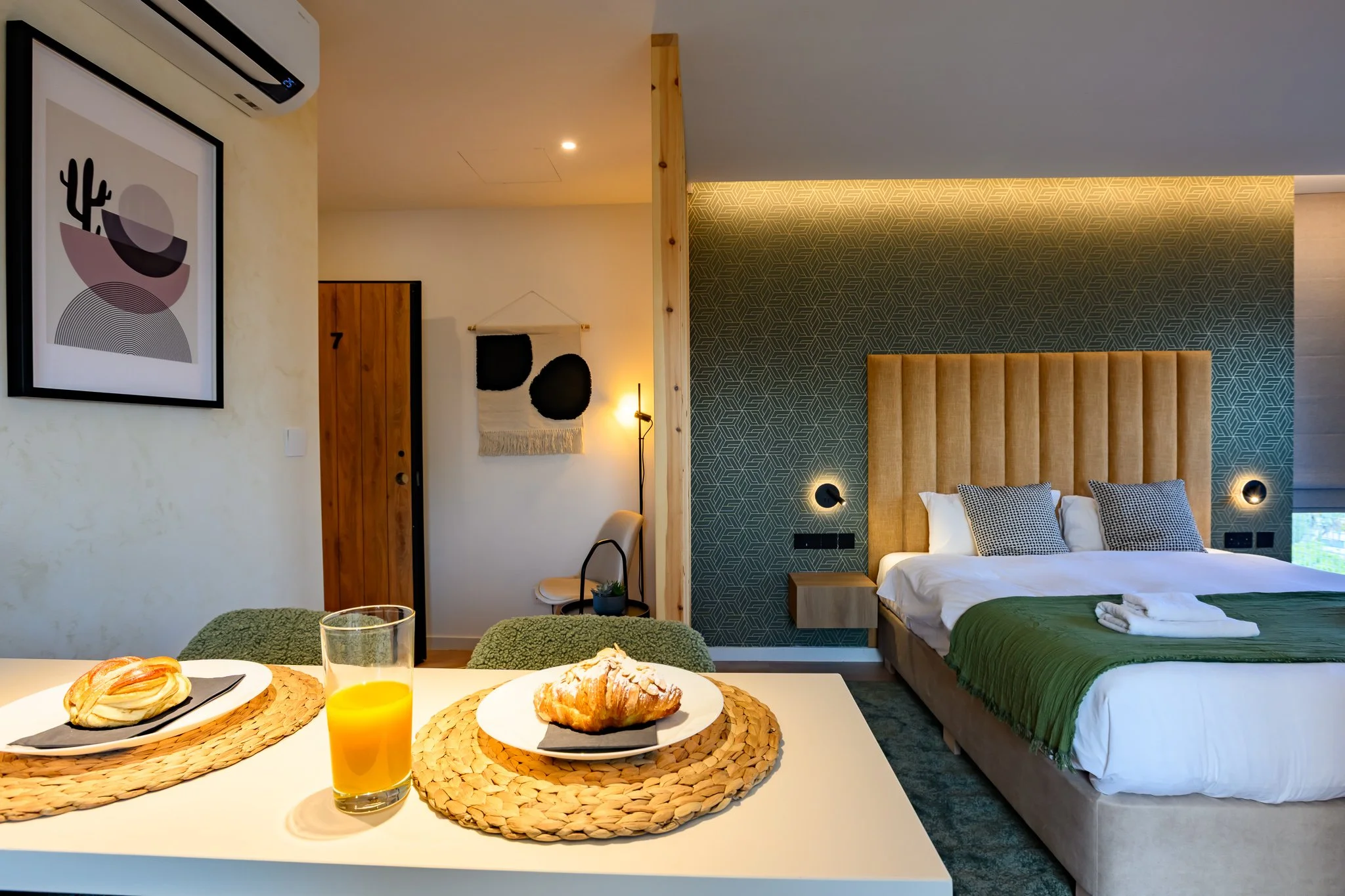 Nisia Suites Corner Suite in Nicosia — breakfast at the kitchen counter with the king bed beyond