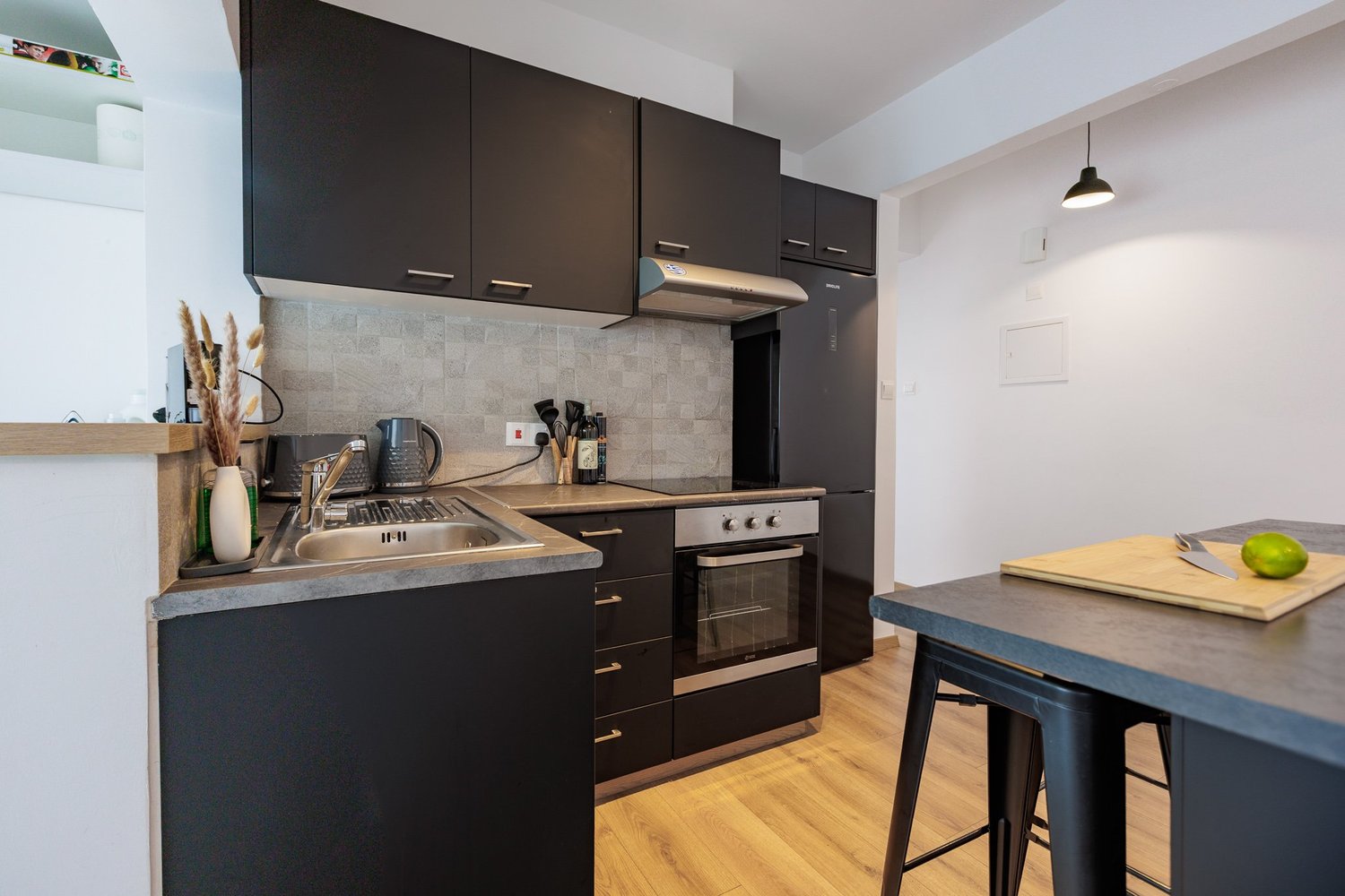 Antoinette Court — Black cabinetry, stone-look tiles