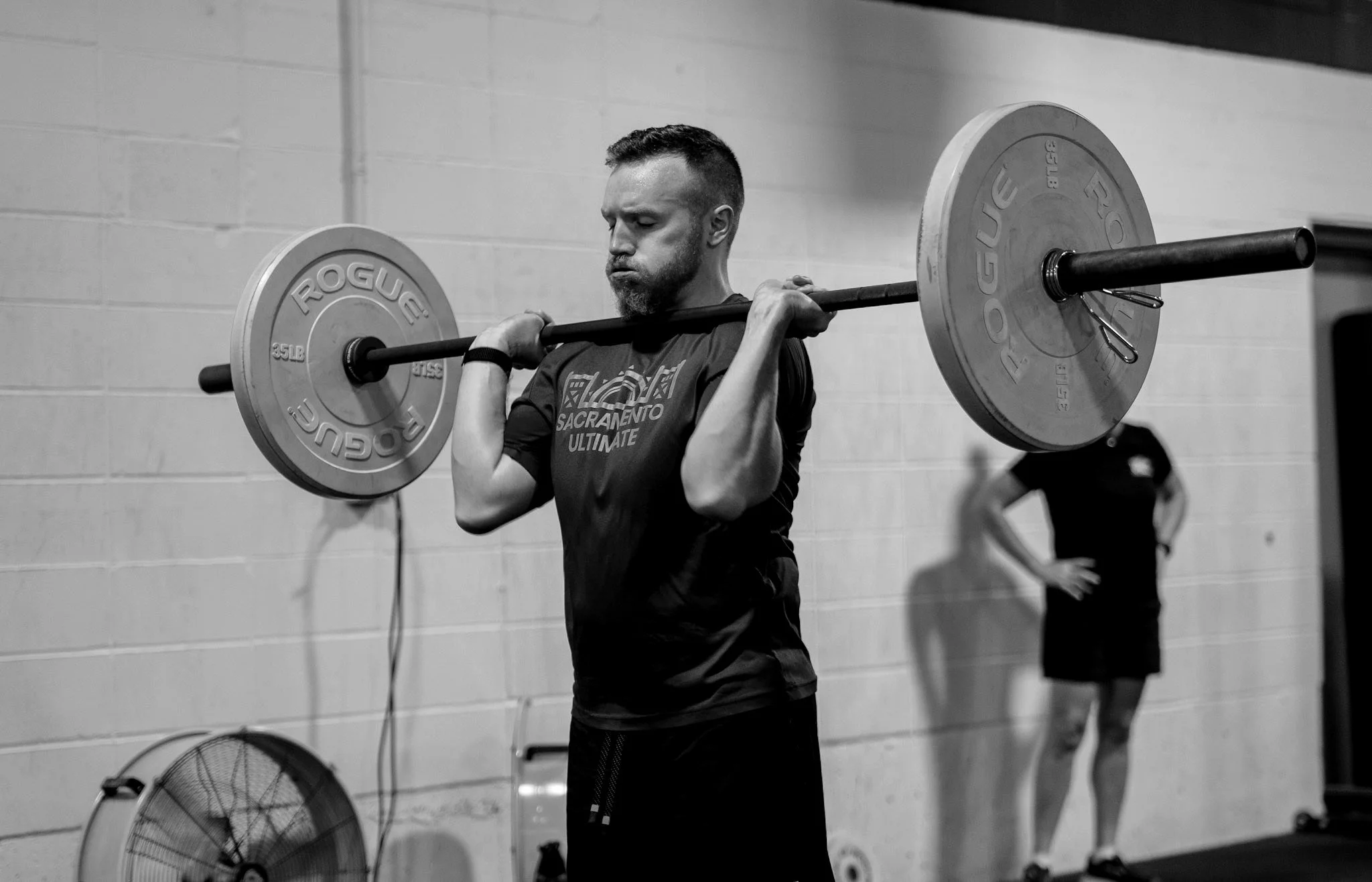 Coefficient member holding a loaded barbell in the front rack