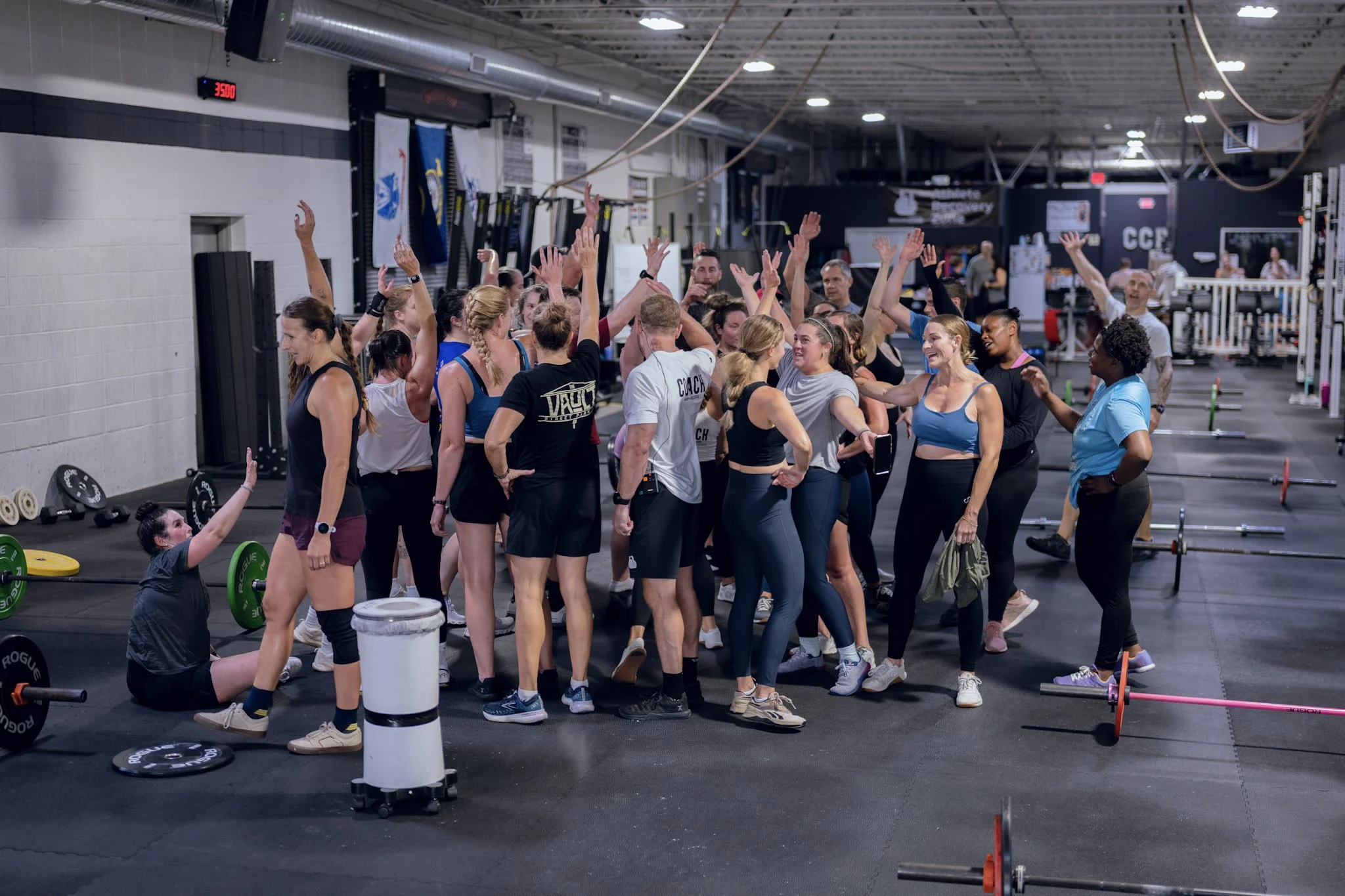 A big group of Coefficient members cheering together on the gym floor