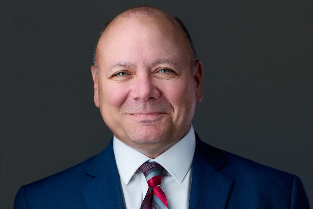 Executive headshot of a man in a blue suit and red tie, Upstate New York