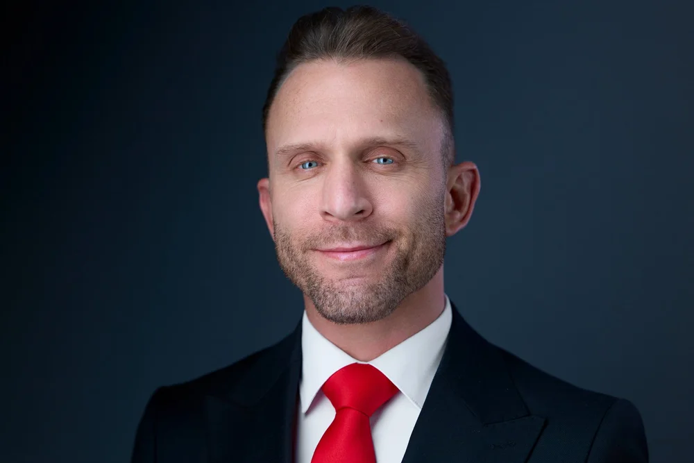 Corporate headshot of a man in a dark suit and red tie, Liverpool NY