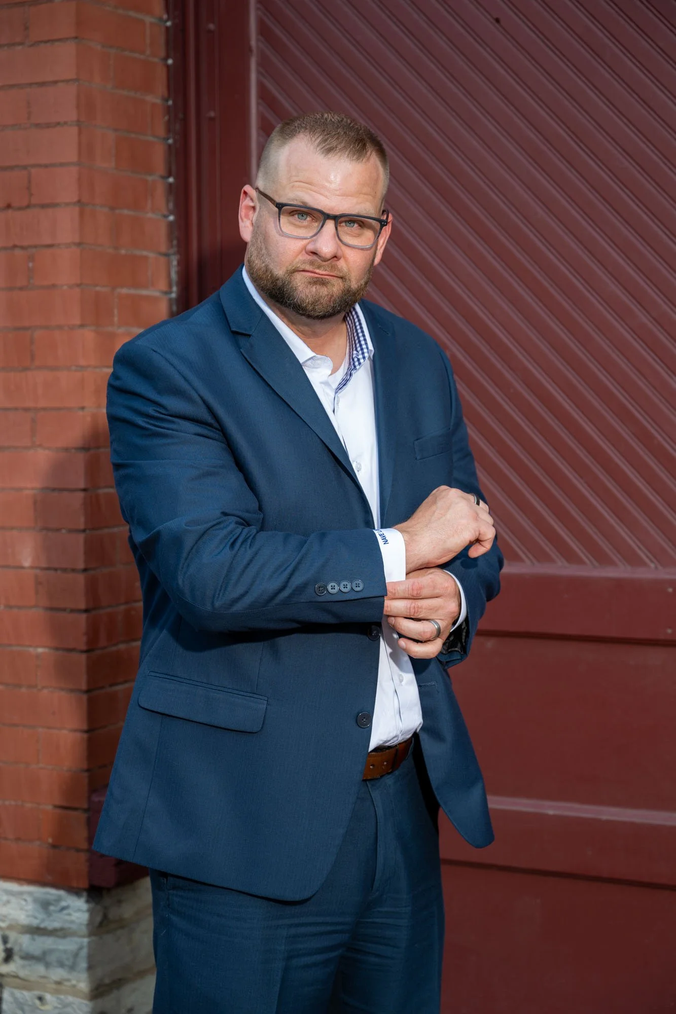 Personal branding photograph of a man in a navy suit against a wood wall, Syracuse NY