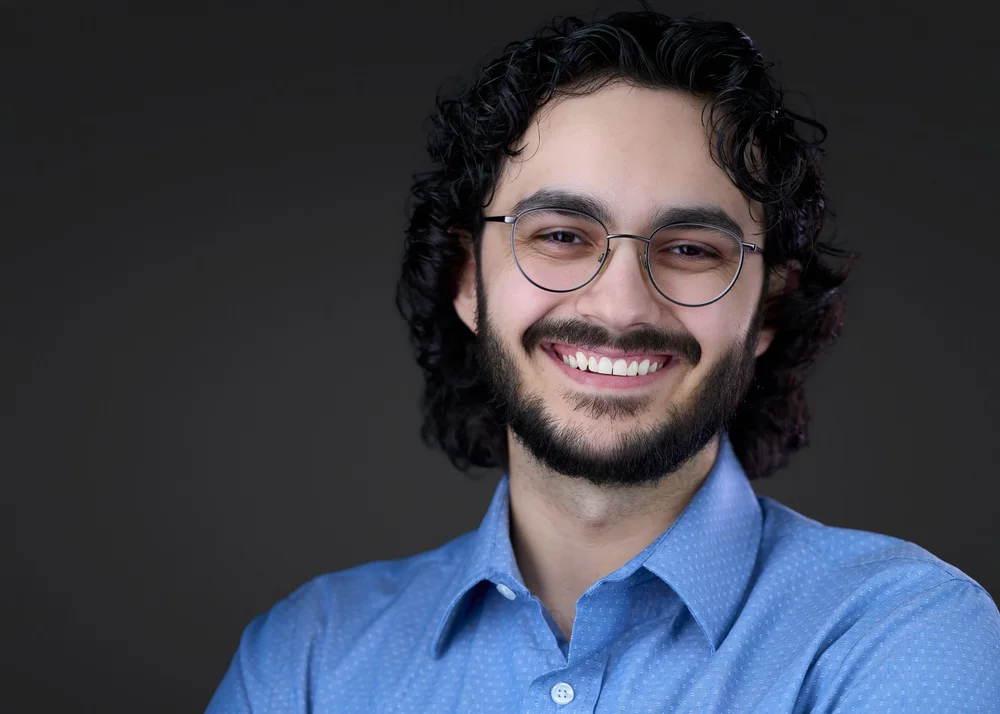 Business headshot of a man in glasses and a blue shirt, Syracuse headshot studio