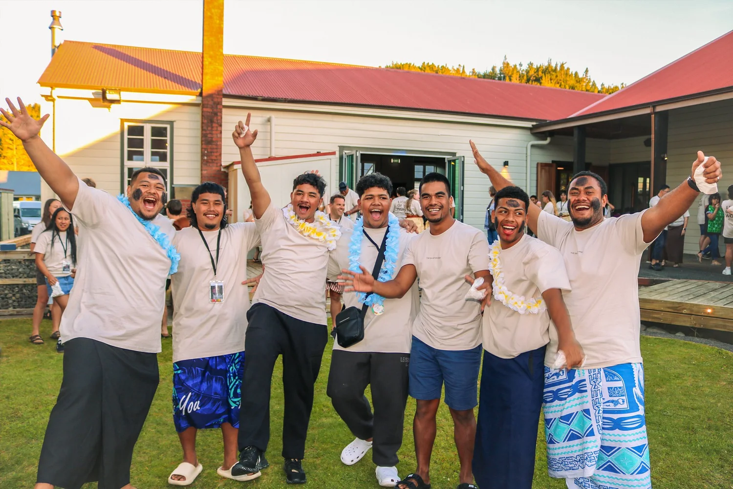 A group of young men in matching white T-shirts cheering at Amplify camp