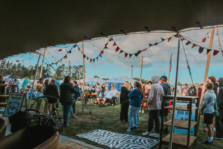 A crowd of young people gathered under a big tent at Easter Camp