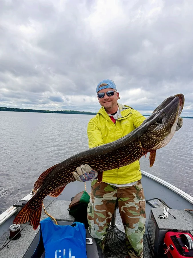 Angler holding a large northern pike caught on Trout Lake
