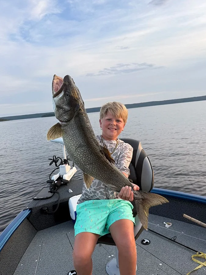 Young angler holding a lake trout caught on Trout Lake