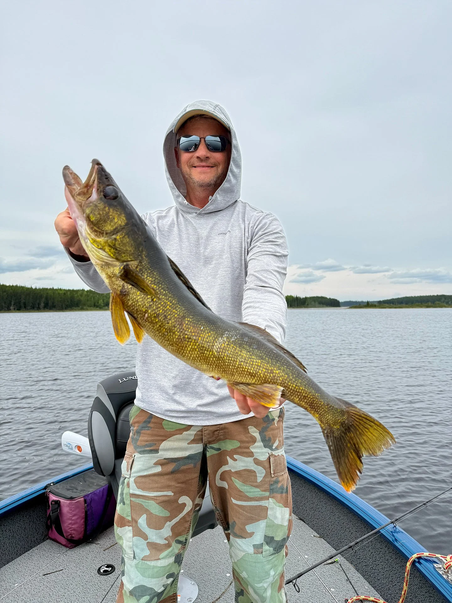 Angler enjoying a remote fishing experience while holding a trophy walleye on Trout Lake in Ontario