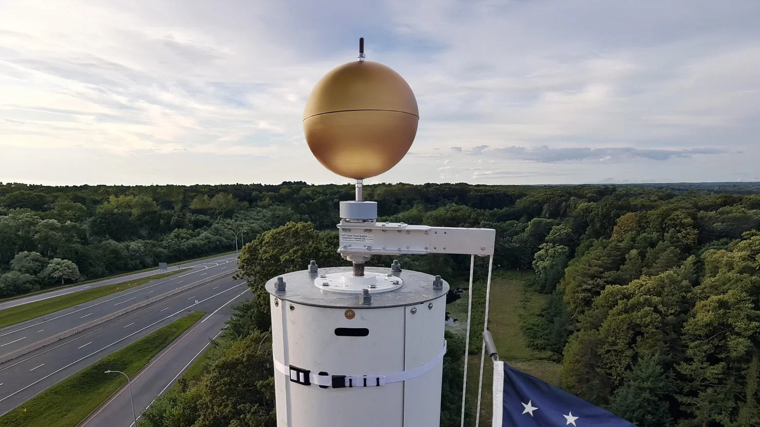 SwingArm Truck and gold Finial Ball on a concealment tower, with a WindBand on the shroud below