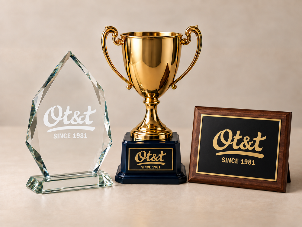 Glass award, gold trophy, and walnut plaque with a black and gold plate.