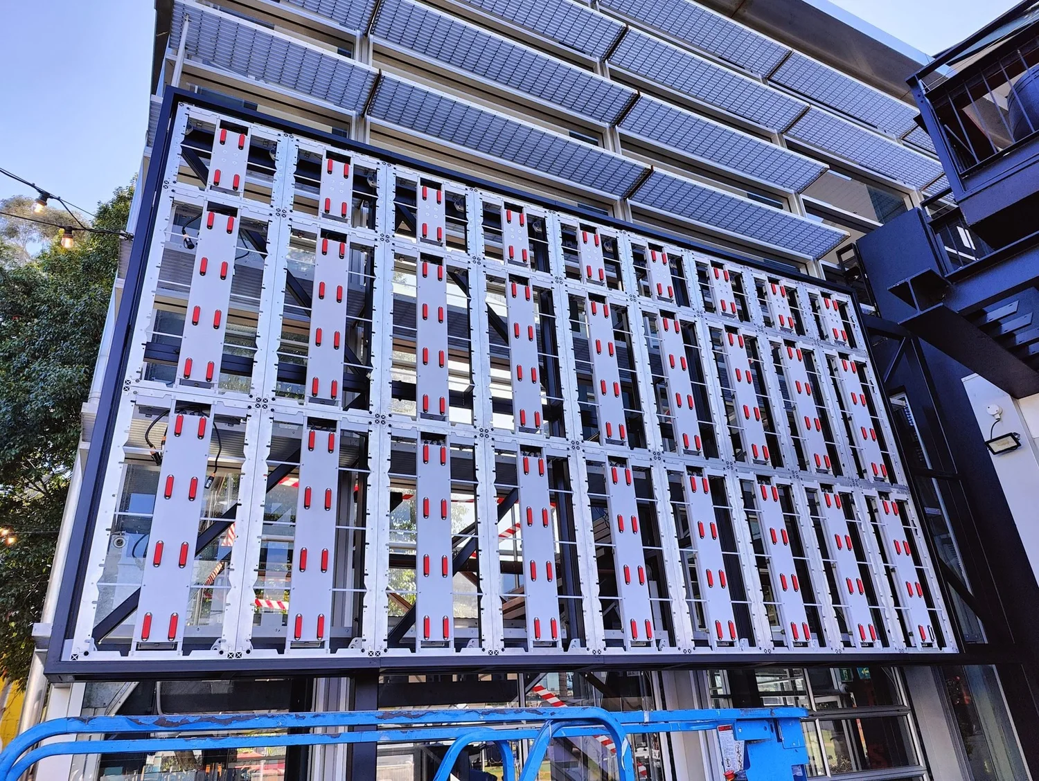 Outdoor LED video wall frame being installed from an elevated work platform by Connective Integrations technicians