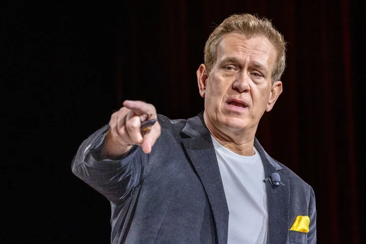 Mitch Mitchem pointing toward the audience while speaking on stage
