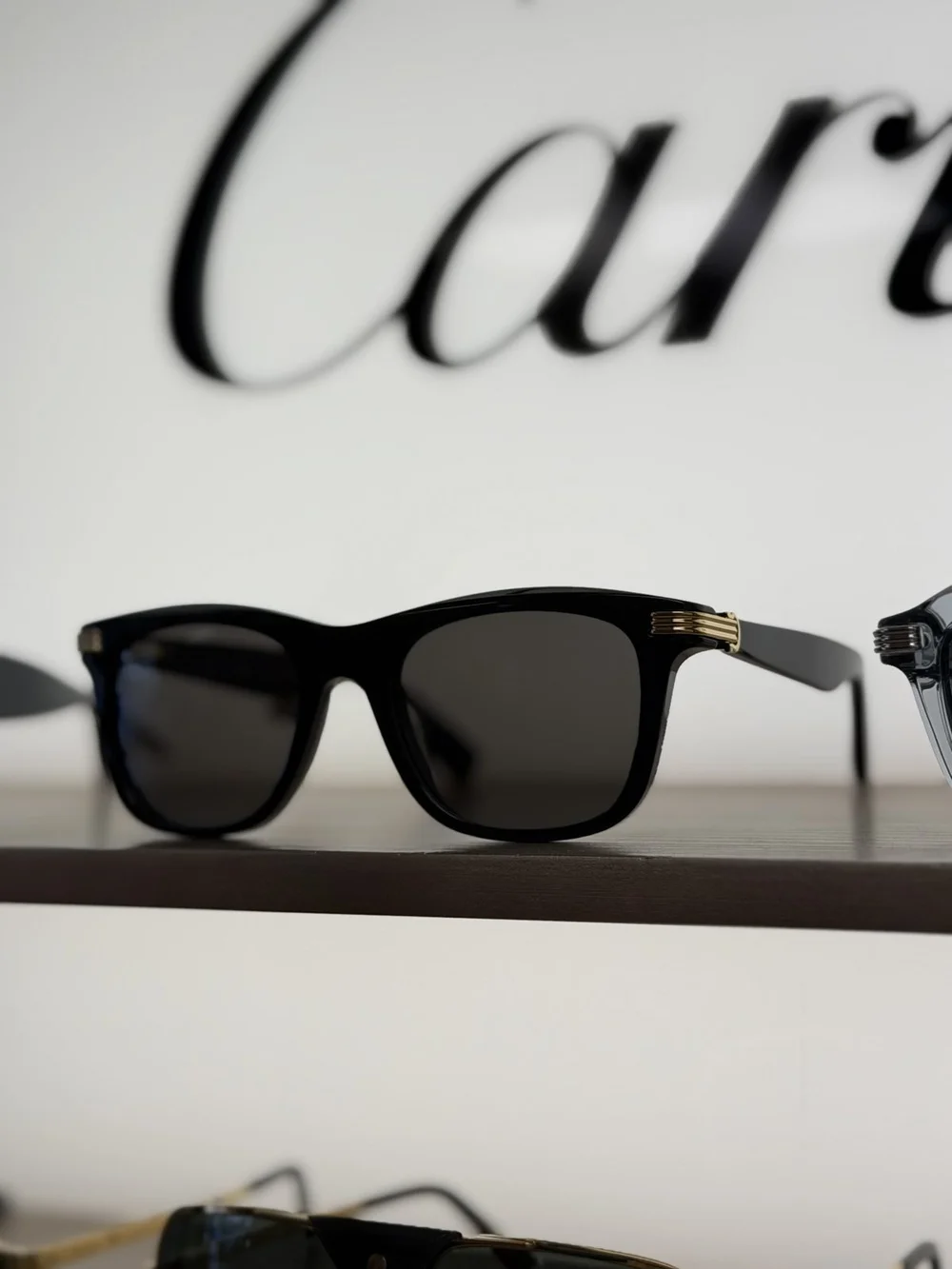 Black Cartier sunglasses with gold details, available at Duovision in Montreal